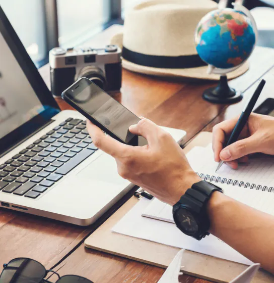 Traveler planning a trip to Peru using a phone and travel notes